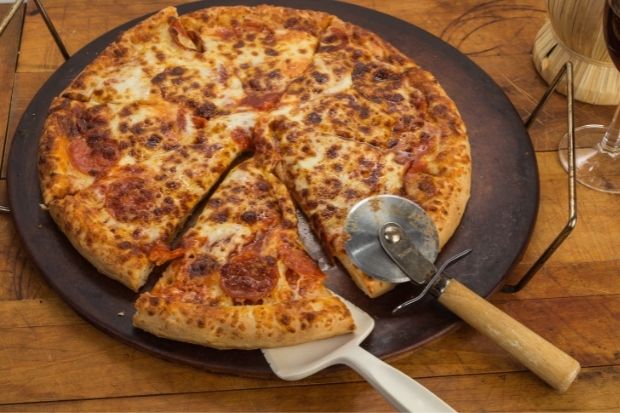 Cooked pizza on pizza stone that can be ruined