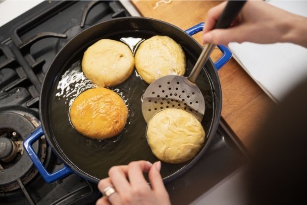 Woman frying homemade donuts that do not have dairy