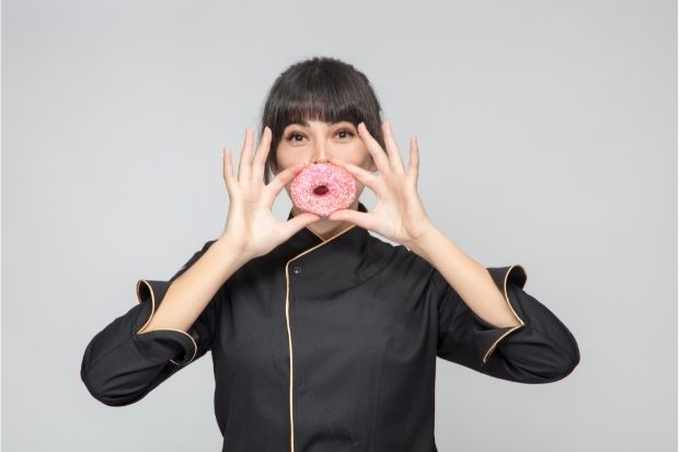 Woman holding donut that has dairy