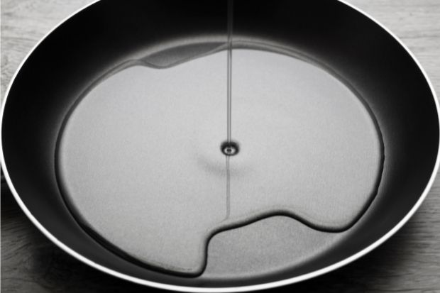 Peanut oil being mixed with vegetable oil in a pan
