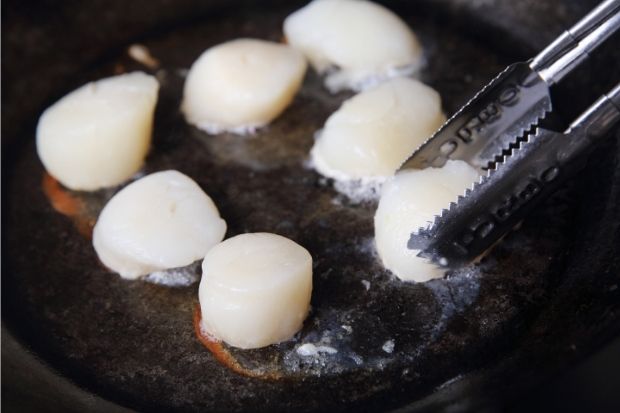 Scallops cooking over oven after chef learned how to tell if scallops are undercooked