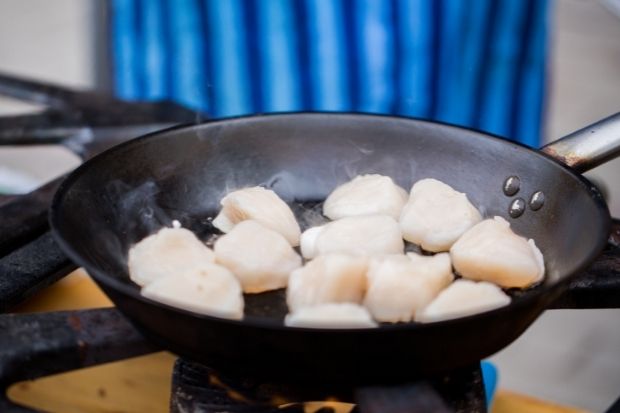Scallops cooking over oven after chef learned how to tell if scallops are undercooked