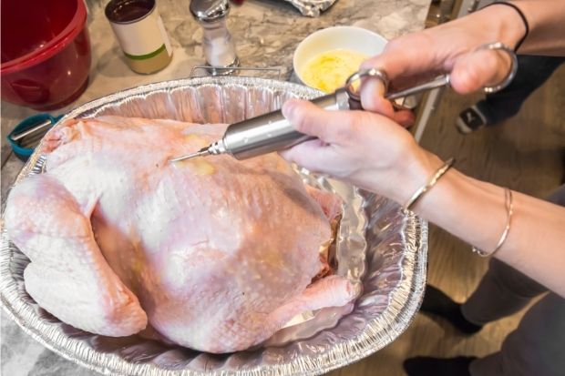 Chef pre-basting turkey before brining