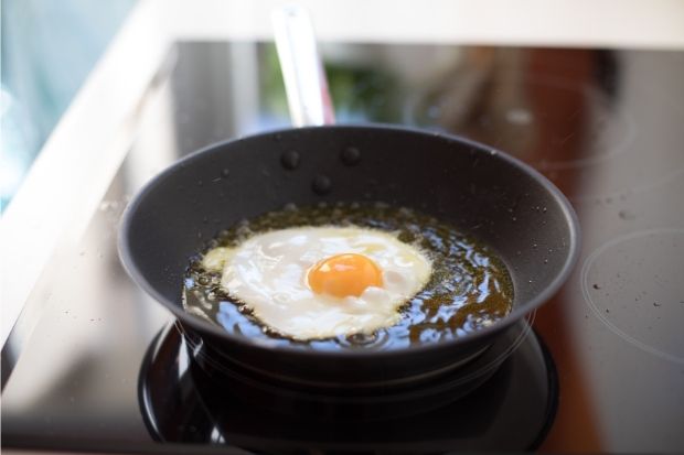 Egg frying in pan after chef learned how to cook eggs without butter