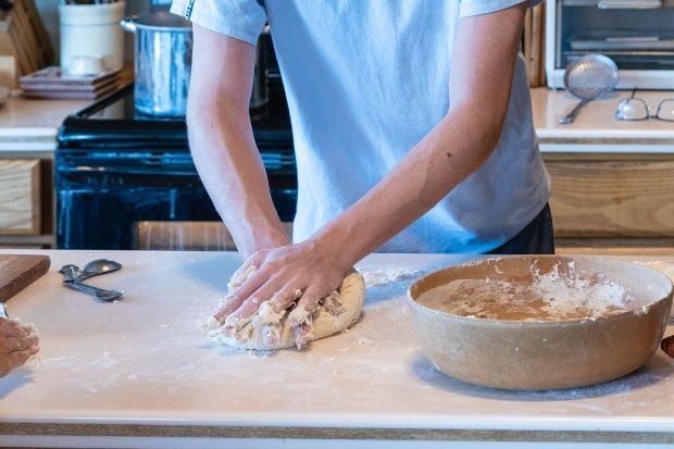 Person kneading dough on the best surface for kneading dough