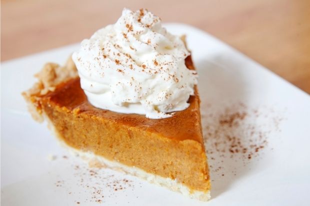 Whipped cream on top of slice of pumpkin pie that you can eat hot or cold
