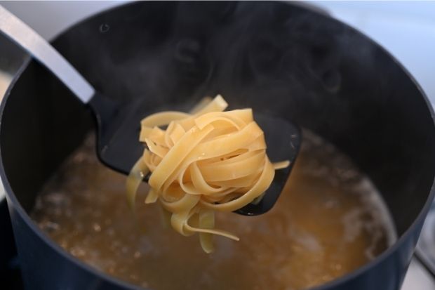 Fettuccine noodles boiling in pot after chef learned how to make fettuccine noodles not stick together