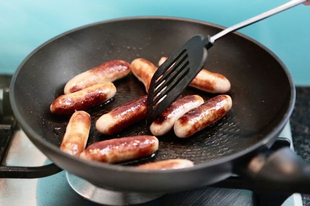 Sausages cooking in pan after chef learned how to keep sausage from shrinking