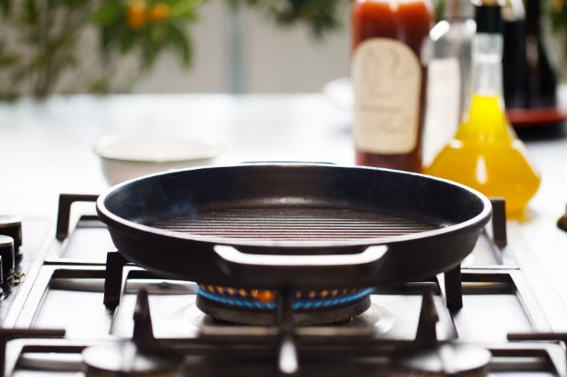 Pan heating up over stove after cook learned how to keep sausage from shrinking