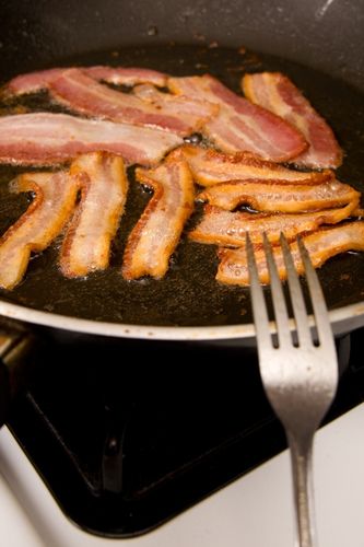 Strips of bacon in pan on low heat so they won't curl up