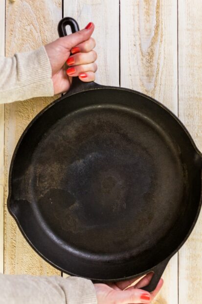 Woman holding cast iron skillet that is sanitary